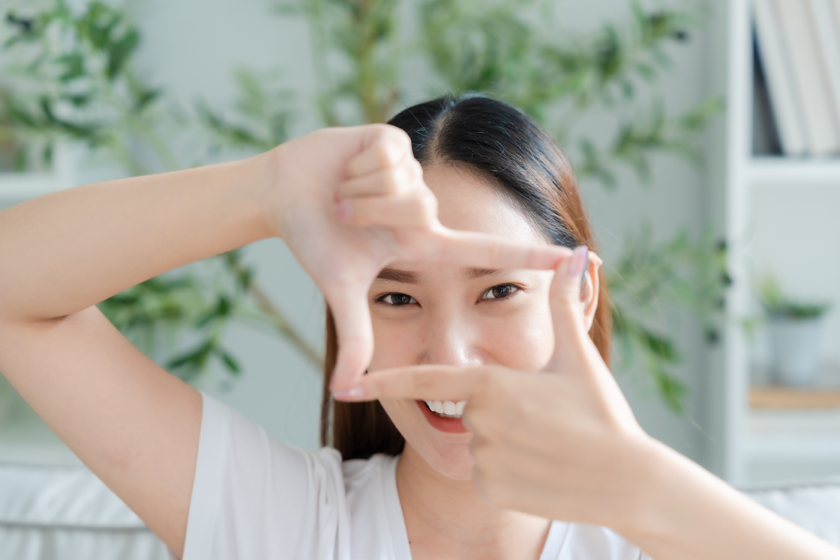 Woman framing her eyes in a rectangle using her hands
